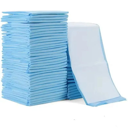 Tall stack of folded blue puppy pads with one pad standing upright to show the white quilted top layer